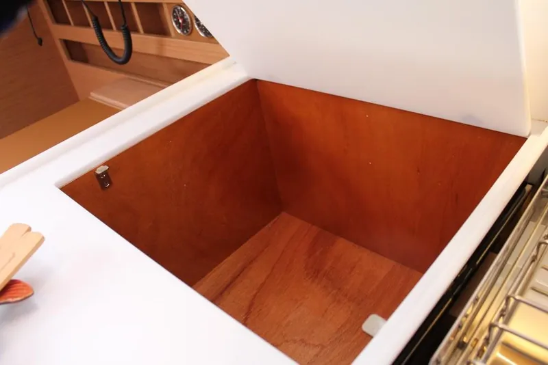 Slide: The Image of Open storage compartment on 2025 Jeanneau Sun Odyssey 440 yacht, featuring wooden interior. - 24
