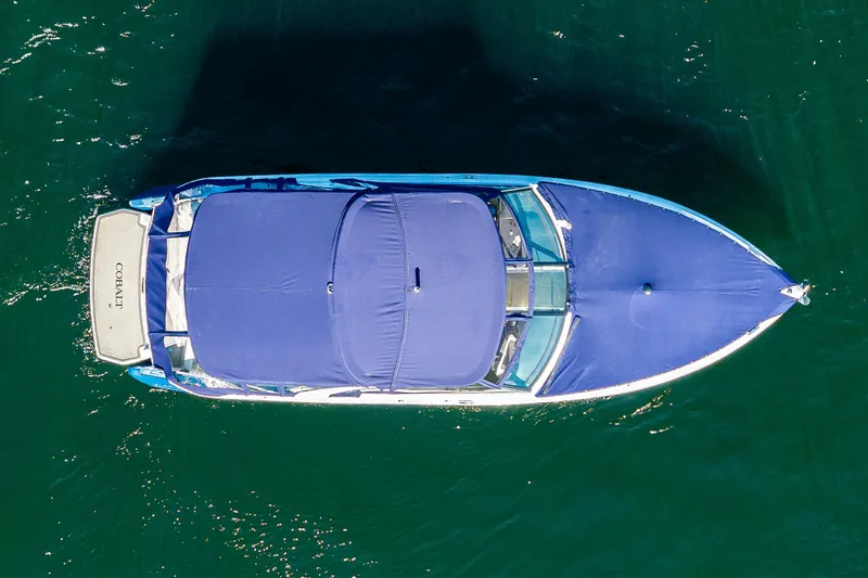Slide: The Image of Aerial view of 2019 Cobalt R30 boat with blue cover on water. - 20