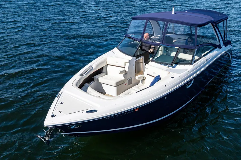 Slide: The Image of 2019 Cobalt R30 boat cruising on open water with blue canopy and seating area. - 22