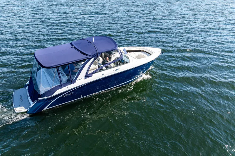 Slide: The Image of 2019 Cobalt R30 boat cruising on open water with blue canopy. - 24