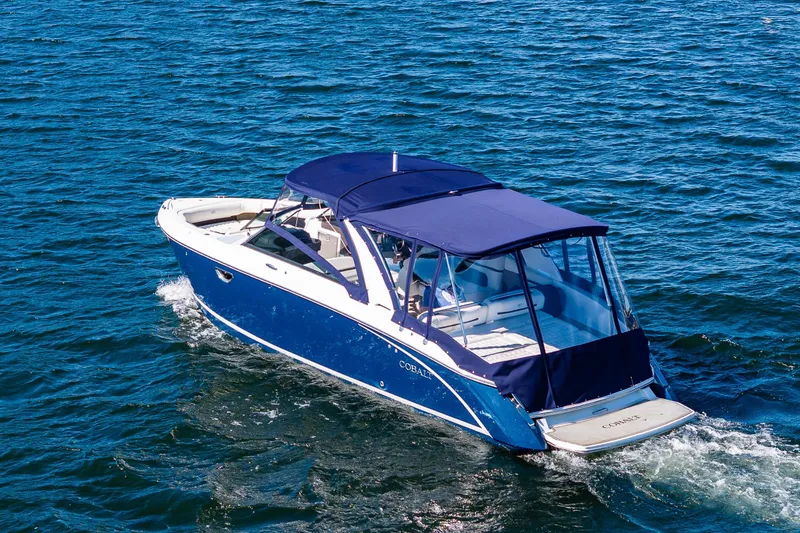Slide: The Image of 2019 Cobalt R30 boat cruising on blue water with a navy canopy. - 32