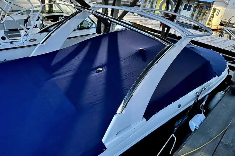 Slide: The Image of 2019 Cobalt R30 boat with blue cover docked at marina. - 35