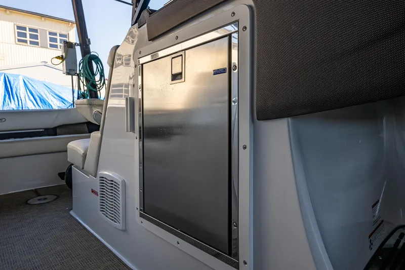 Slide: The Image of 2019 Cobalt R30 boat interior with stainless steel refrigerator and seating area. - 6