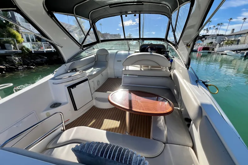 Slide: The Image of 2007 Larson Cabrio 310 boat interior with seating, table, and water view. - 13