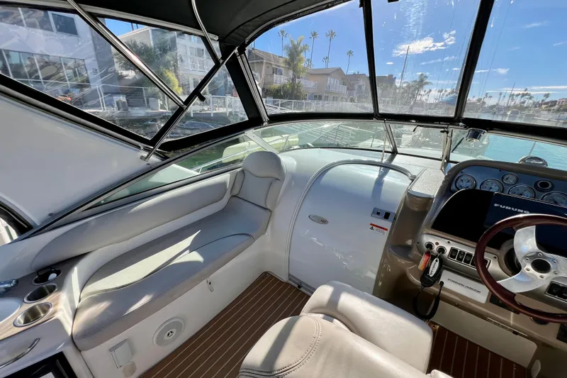 Slide: The Image of Interior of a 2007 Larson Cabrio 310 boat, featuring a sleek dashboard and comfortable seating. - 19