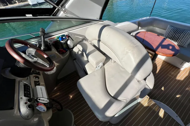 Slide: The Image of 2007 Larson Cabrio 310 boat interior with steering wheel, seating, and table. - 21