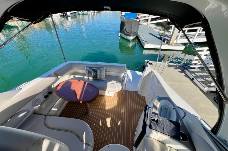 Slide: The Image of 2007 Larson Cabrio 310 boat interior with seating, table, and dock view. - 28
