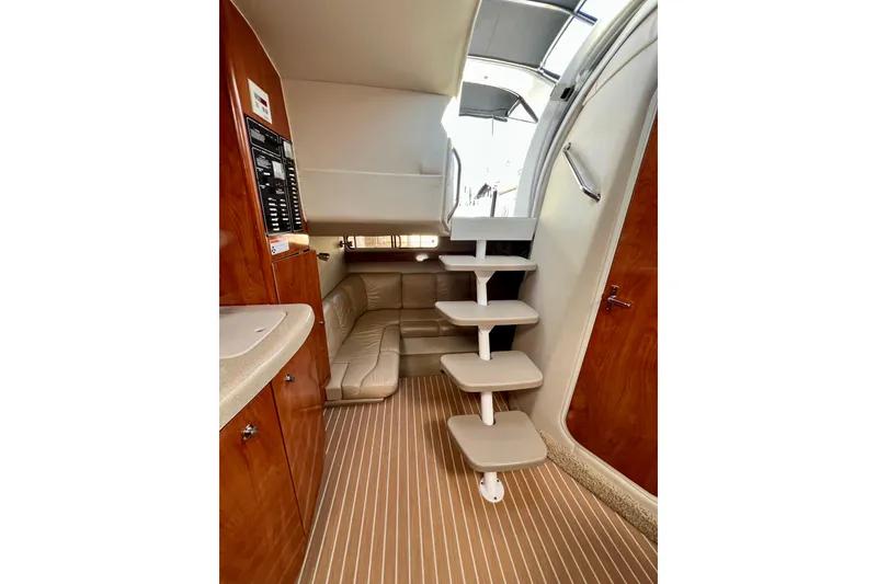 Slide: The Image of 2007 Larson Cabrio 310 interior with wooden cabinetry, beige seating, and modern staircase. - 29