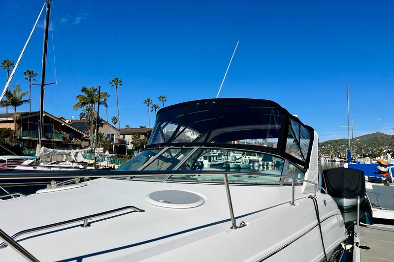 Slide: The Image of 2007 Larson Cabrio 310 boat docked in a sunny marina with palm trees. - 3