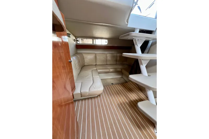Slide: The Image of Interior of 2007 Larson Cabrio 310 boat with beige leather seating and wooden flooring. - 30