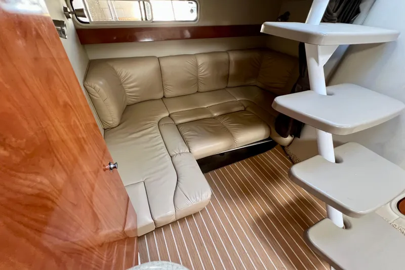 Slide: The Image of Interior of 2007 Larson Cabrio 310 boat with beige leather seating and wooden flooring. - 32