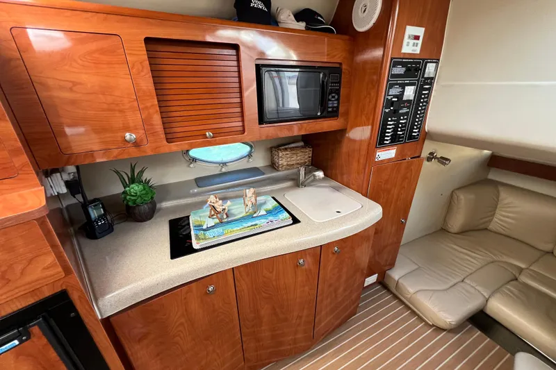 Slide: The Image of 2007 Larson Cabrio 310 cabin interior with kitchenette, microwave, and seating area. - 36