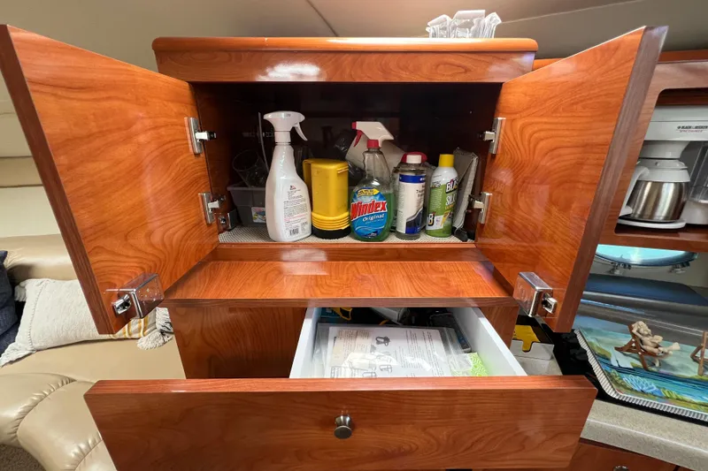 Slide: The Image of Open wooden cabinet in 2007 Larson Cabrio 310, storing cleaning supplies and documents. - 41