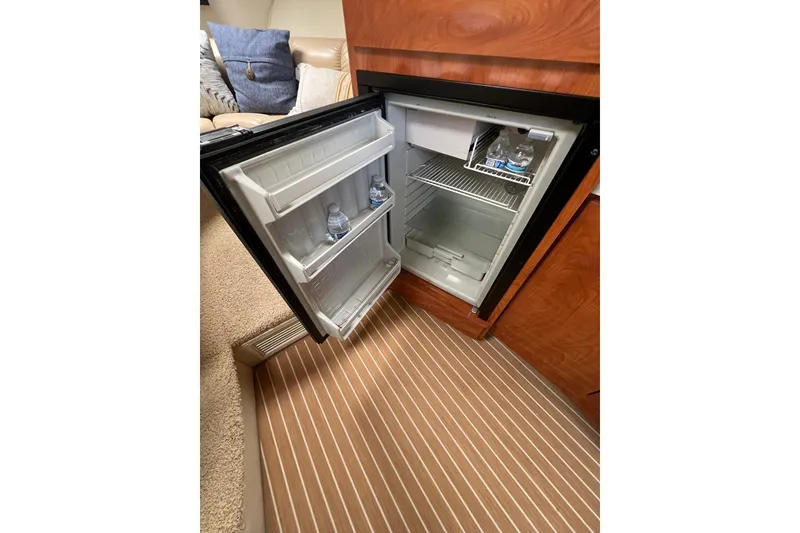 Slide: The Image of Open mini fridge in 2007 Larson Cabrio 310 boat interior, stocked with water bottles. - 42