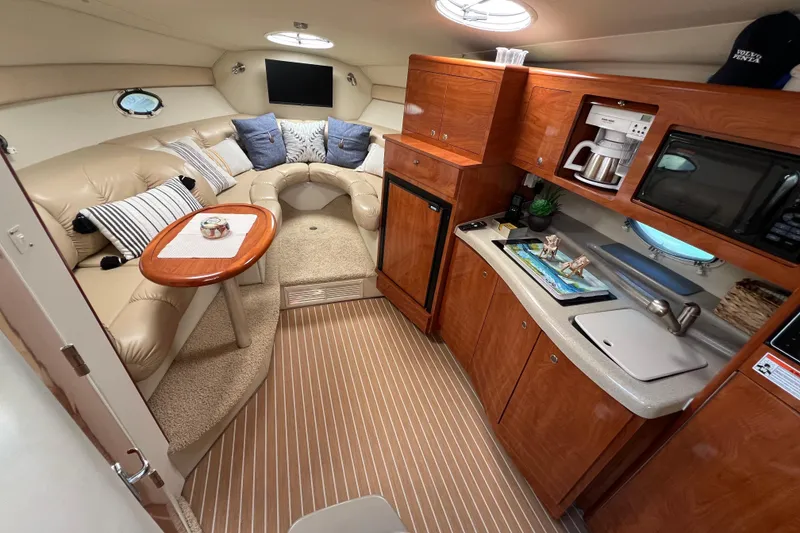 Slide: The Image of Interior of 2007 Larson Cabrio 310 boat with cozy seating and modern kitchenette. - 43