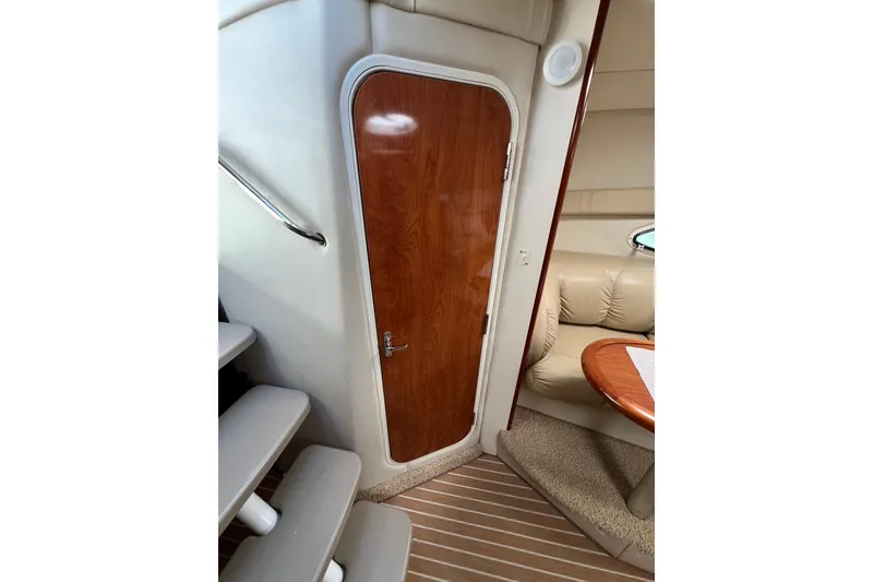 Slide: The Image of Interior of 2007 Larson Cabrio 310 yacht with wooden door and seating area. - 48