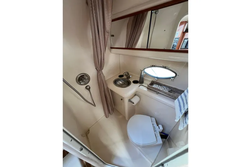 Slide: The Image of 2007 Larson Cabrio 310 boat bathroom with sink, toilet, and shower. - 50
