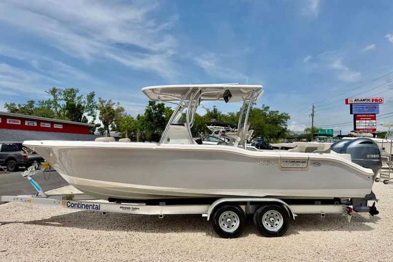 The Image of 2021 Key West 263 FS boat on trailer, parked outdoors under clear sky. - 0