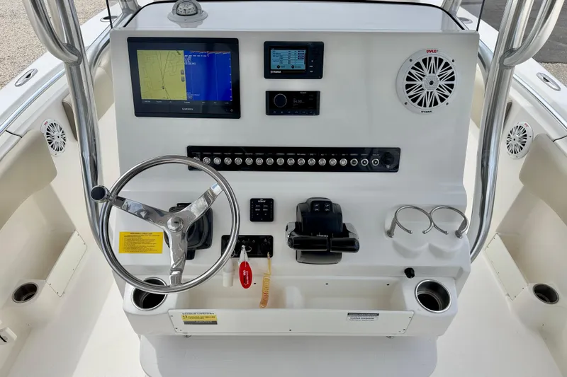 Slide: The Image of 2021 Key West 263 FS boat dashboard with steering wheel, navigation screens, and controls. - 13