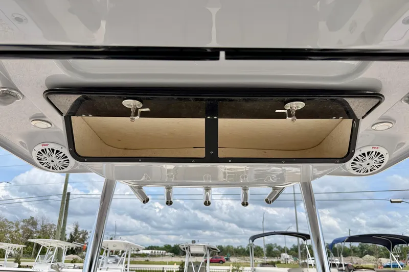 Slide: The Image of 2021 Key West 263 FS boat overhead storage and speakers under a cloudy sky. - 18
