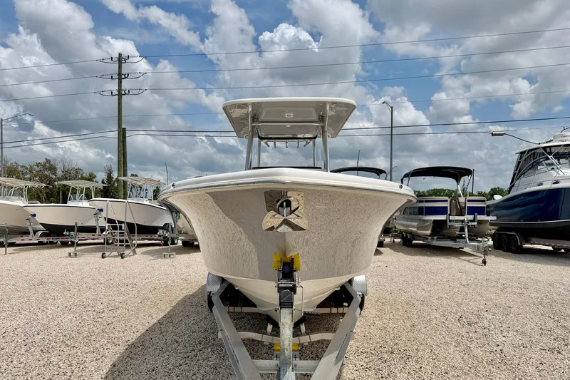 Slide: The Image of 2021 Key West 263 FS boat on trailer under cloudy sky at dealership. - 2