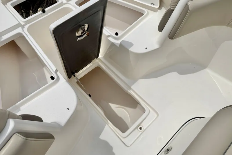 Slide: The Image of 2021 Key West 263 FS boat storage compartments with open hatch and seating area. - 29