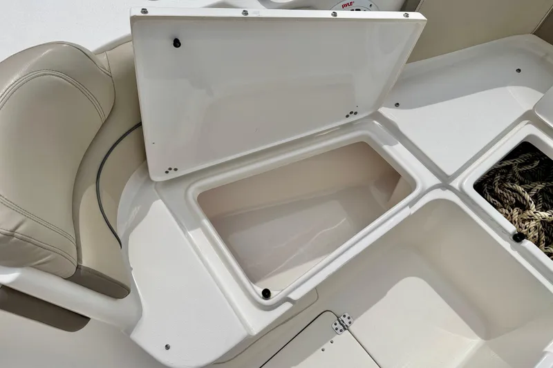 Slide: The Image of Open storage compartments on a 2021 Key West 263 FS boat, featuring beige seating. - 31