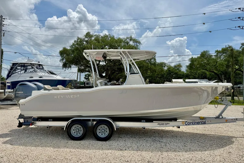Slide: The Image of 2021 Key West 263 FS boat on trailer, parked outdoors under a cloudy sky. - 4