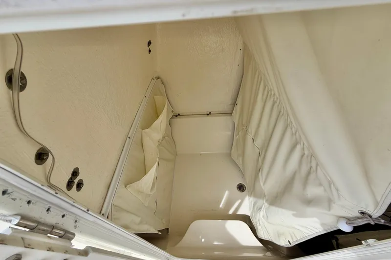 Slide: The Image of Interior storage compartment of a 2021 Key West 263 FS boat, featuring white fabric lining. - 42