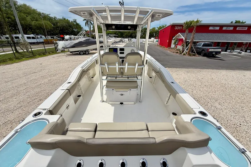 Slide: The Image of 2021 Key West 263 FS boat interior with seating and console, parked outdoors. - 9
