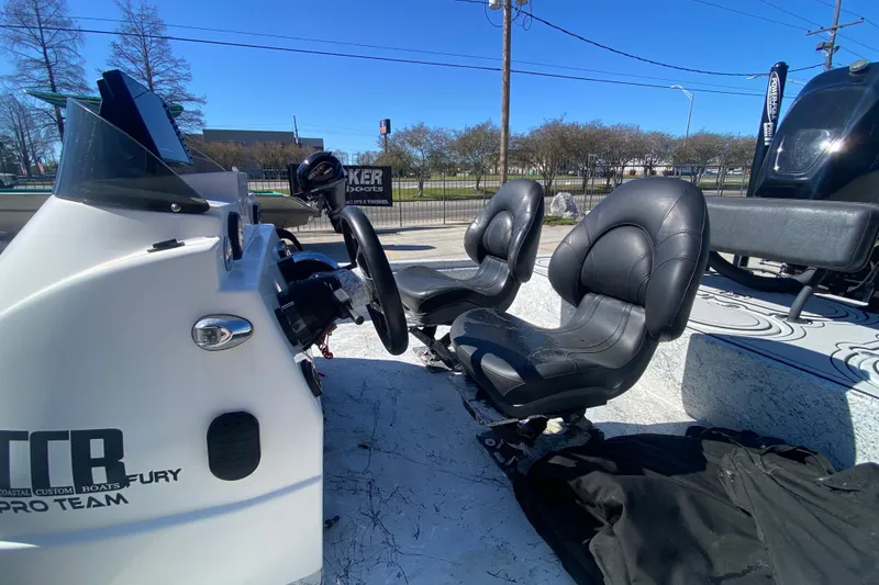 Slide: The Image of Interior of a 2020 Coastal Custom Boats 23' Fury, featuring dual black seats and steering console. - 17