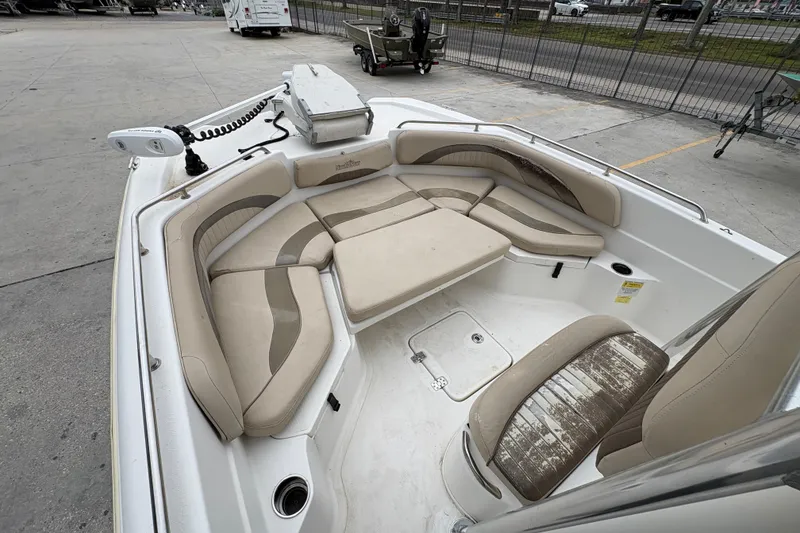 Slide: The Image of 2014 NauticStar 210 Coastal boat interior with beige seating and storage compartments. - 15