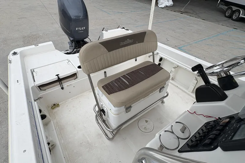 Slide: The Image of 2014 NauticStar 210 Coastal boat interior with seating and Yamaha 150 engine. - 18