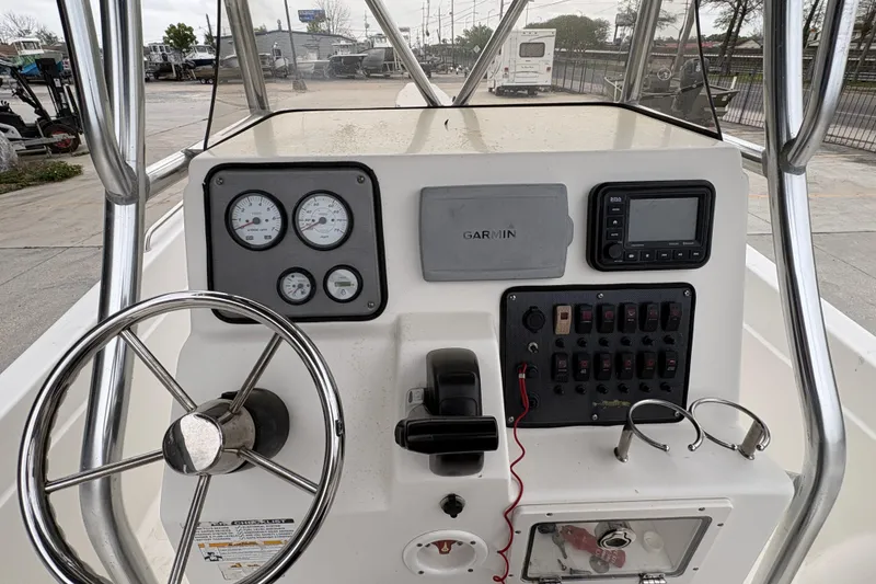 Slide: The Image of 2014 NauticStar 210 Coastal boat dashboard with steering wheel, gauges, and Garmin navigation system. - 19