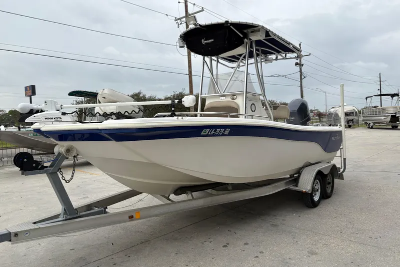 Slide: The Image of 2014 NauticStar 210 Coastal boat on trailer, featuring a Minn Kota trolling motor. - 8