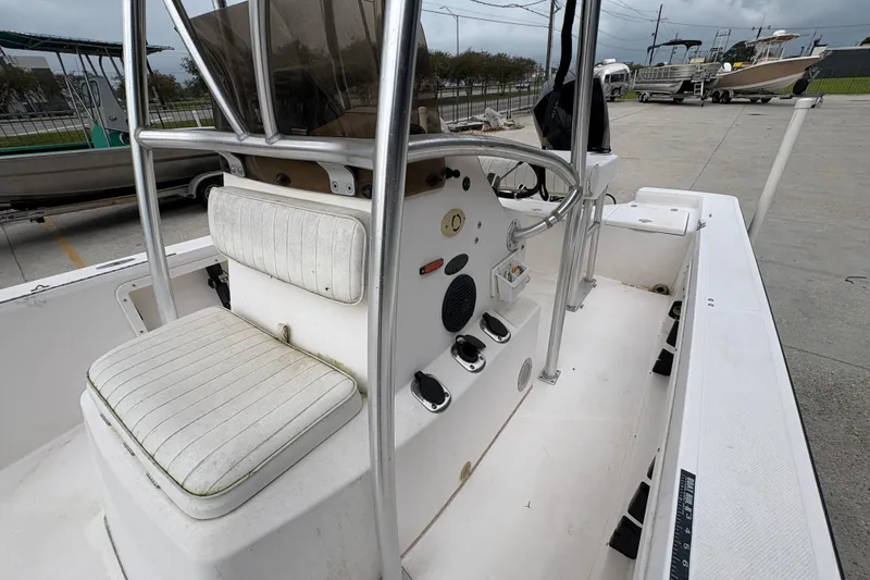 Slide: The Image of Kenner 21 VISION 2000 boat interior with steering console and seating, docked outdoors. - 14