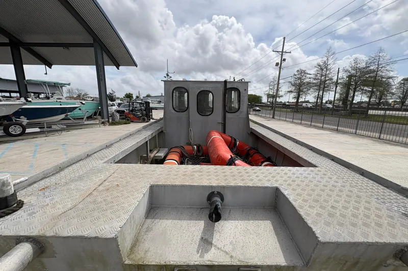 Slide: The Image of 1972 Custom 23' work/push boat with metal deck, docked outdoors under cloudy sky. - 12