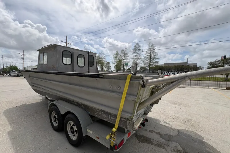 Slide: The Image of 1972 Custom 23' work/push boat on trailer, parked outdoors under cloudy sky. - 6