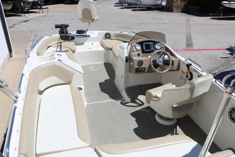 Slide: The Image of 2015 Stingray 192 SC boat interior with beige seating and modern dashboard controls. - 19
