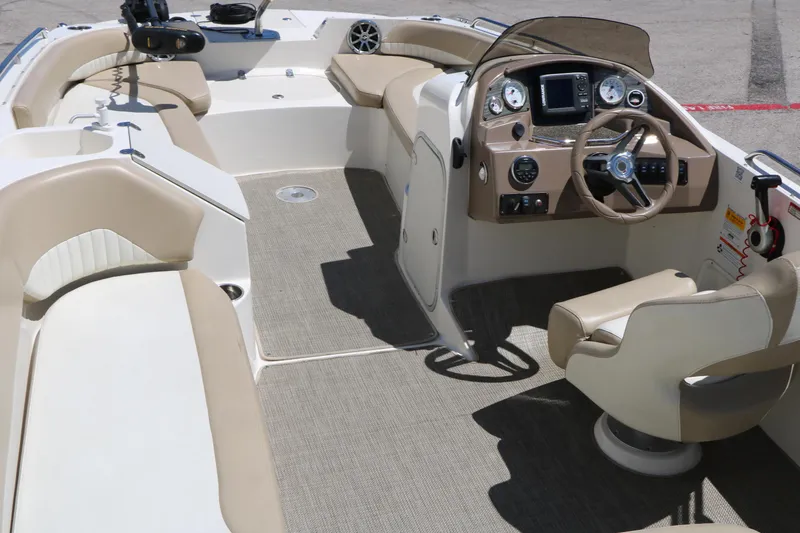 Slide: The Image of 2015 Stingray 192 SC boat interior with beige seating and modern dashboard. - 21