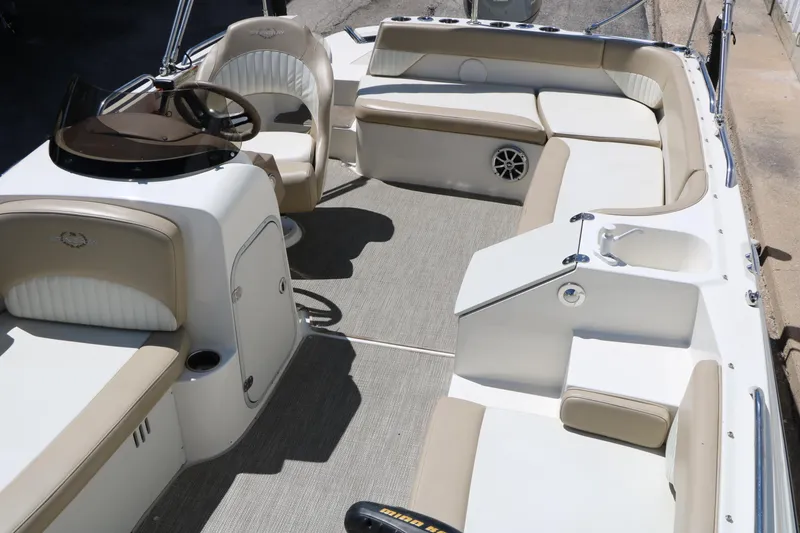 Slide: The Image of 2015 Stingray 192 SC boat interior with beige seating and steering console. - 27