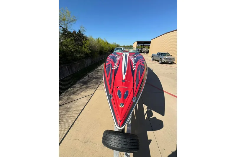Slide: The Image of 2005 Baja 342 Boss speedboat with vibrant red and black design on a trailer. - 10