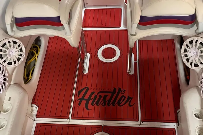 Slide: The Image of Red deck of 2005 Baja 342 Boss boat with "Hustler" branding and white seating. - 6