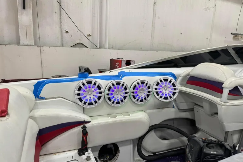 Slide: The Image of Interior of a 2005 Baja 342 Boss boat with illuminated speakers and white seating. - 8