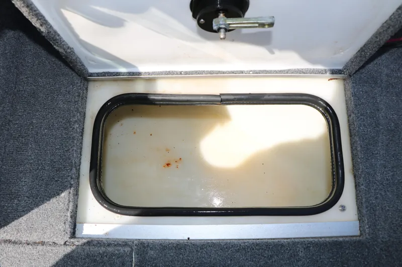 Slide: The Image of 2008 Alumacraft Dominator 165 Sport boat storage compartment with latch, carpeted interior. - 23