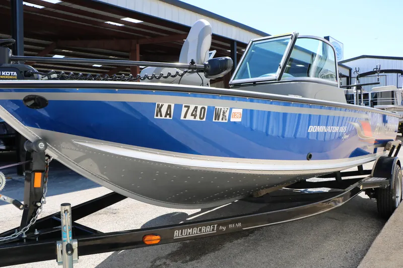 Slide: The Image of 2008 Alumacraft Dominator 165 Sport boat on trailer, blue and silver design. - 4