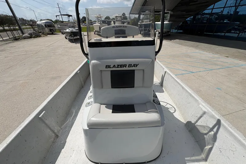 Slide: The Image of 2020 Blazer Bay 2170 boat interior with seating and console, parked outdoors. - 14