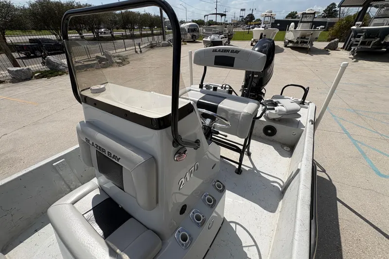 Slide: The Image of 2020 Blazer Bay 2170 boat interior with console and seating, parked outdoors. - 16