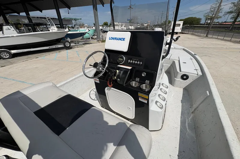Slide: The Image of 2020 Blazer Bay 2170 boat interior with steering console and seating, parked outdoors. - 20