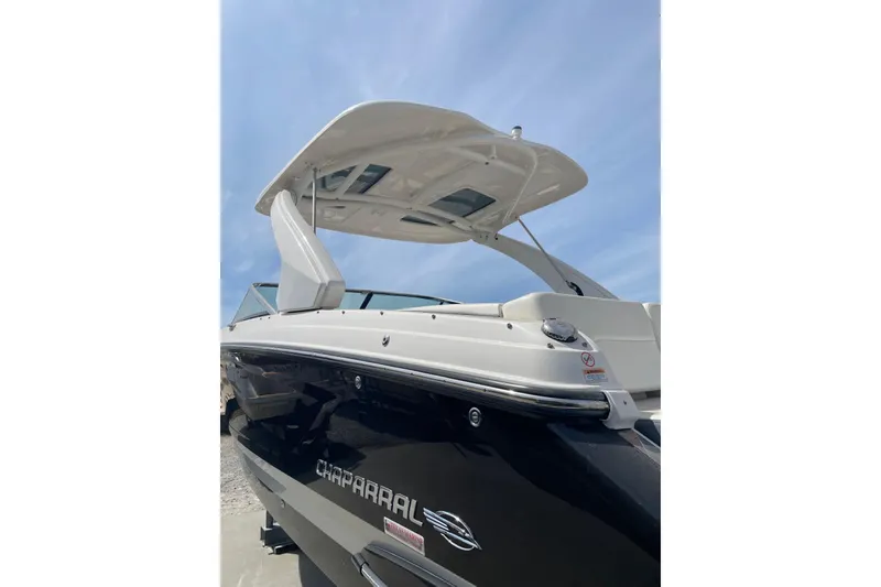 Slide: The Image of 2019 Chaparral 297 SSX boat with sleek black hull and modern design. - 10